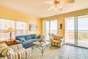 a living room with a blue couch and two chairs at Stingray Isle in Dauphin Island
