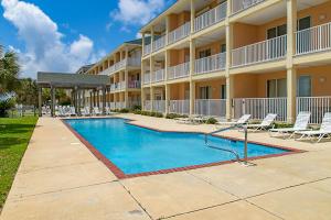 a swimming pool in front of a building at Stingray Isle in Dauphin Island