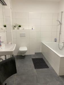 ein Badezimmer mit einer Badewanne, einem WC und einem Waschbecken in der Unterkunft Wunderschöne, neue Wohnung mit großer Terrasse in Ebenthal