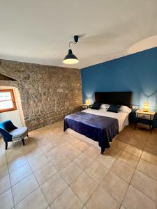 um quarto com uma cama e uma parede azul em Cal Ganyada, Casa Rural Cardona em Cardona