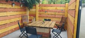a wooden table and chairs in front of a fence at La petite ligérienne in Villebernier