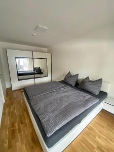 1 dormitorio con 1 cama grande y espejo grande en Wunderschöne, neue Wohnung mit großer Terrasse, en Ebenthal