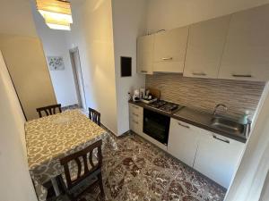 a small kitchen with a table and a sink at Albemarooms in Noto