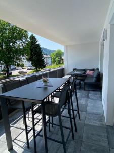 a patio with two tables and chairs and a couch at Wunderschöne, neue Wohnung mit großer Terrasse in Ebenthal