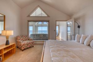 1 dormitorio con 1 cama grande y 1 silla en Beach Loop Condos, en Bandon
