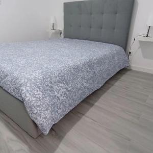 1 dormitorio con 1 cama con edredón gris en Casa do Ferrador, en Moura