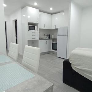 Habitación blanca con cama y cocina en Casa do Ferrador, en Moura