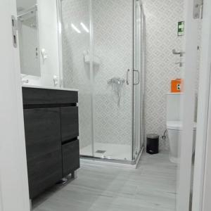 a bathroom with a glass shower and a toilet at Casa do Ferrador in Moura