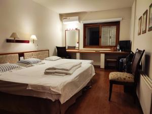 a bedroom with a bed and a desk and a chair at Suíte 455 Wish Resort Gramado in Gramado