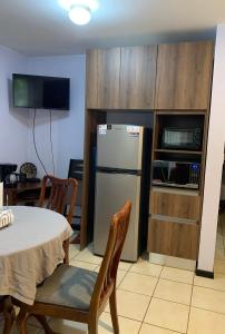 a kitchen with a table and a refrigerator at Cocomarindo Condo #72 in Coco