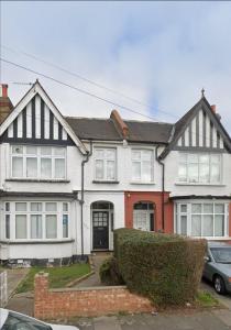 a white and red house with a car parked in front at Amazing 2 bed London apartment in London