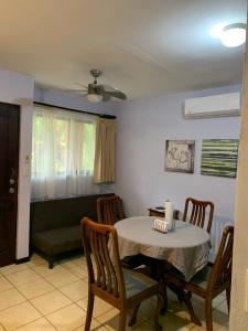 uma sala de jantar com uma mesa e cadeiras e um sofá em Cocomarindo Condo #72 em Coco