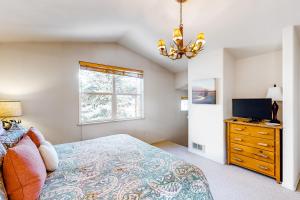 a bedroom with a bed and a tv and a window at Sun Bird Getaway at River Run in Ketchum