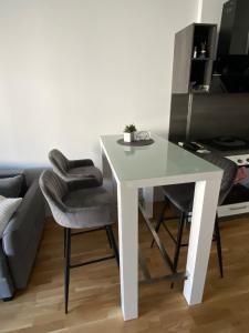 a white table and chairs in a room with a couch at Wunderschöne, neue Wohnung mit großer Terrasse in Ebenthal