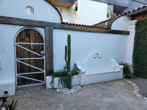 a white building with a door and a cactus at Hermosa Hacienda Las Heliconias in Oaxaca City