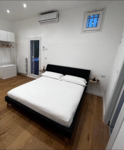 ein Schlafzimmer mit einem weißen Bett und einem Fenster in der Unterkunft Residence Terrazza Perez - appartamento indipendente in Foggia