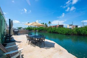 a table with chairs and an umbrella next to a river at Fisherman's Retreat in Conch Key