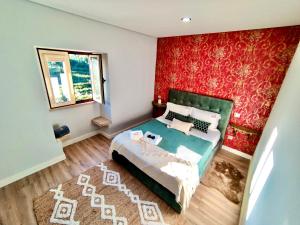 een slaapkamer met een bed en een rode muur bij Labrugia Villa Domus Casa 1 in Codeçal