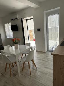 ein Wohnzimmer mit einem weißen Tisch und Stühlen in der Unterkunft Mazzella Home in Ischia