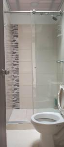 a bathroom with a toilet and a glass shower at Donde Memo in Santa Rosa de Cabal