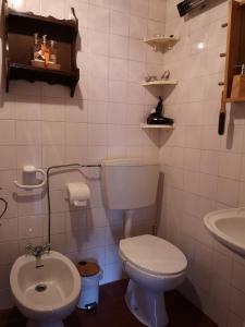 a white bathroom with a toilet and a sink at Toca do Esquilo - Montesinho in Montezinho