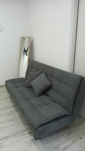 ein graues Sofa in einem Zimmer mit Spiegel in der Unterkunft Mazzella Home in Ischia