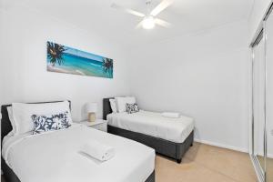 1 dormitorio con 2 camas y ventilador de techo en Harbour Quays Apartments, en Gold Coast