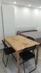 einen Holztisch und einen Stuhl vor einem Bett in der Unterkunft Mazzella Home in Ischia