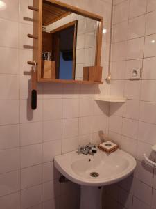 a bathroom with a white sink and a mirror at Toca do Esquilo - Montesinho in Montezinho