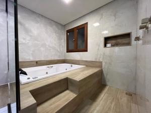 uma casa de banho com banheira e chuveiro em Pousada Sete Mares em Maragogi