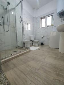 łazienka z 2 toaletami i przeszkloną kabiną prysznicową w obiekcie Green Villa w Durrës
