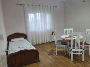 a bedroom with a bed and a table and chairs at Green Villa in Durrës