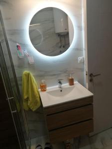 une salle de bain avec un lavabo et un miroir dans l'établissement Sunflower apartment, à Niš 19 autres photos