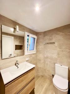uma casa de banho com um lavatório branco e um WC. em ¡Precioso bajo a estrenar! em Platja d'Aro