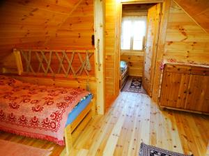 een slaapkamer met een bed in een blokhut bij Chatka Rumcajsa nad Biebrzą 