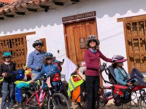 un grupo de personas con bicicletas delante de un edificio en Hostel Once Once, en Villa de Leyva