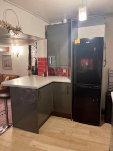 a kitchen with a black refrigerator and a counter at Cathedral View in Gloucester