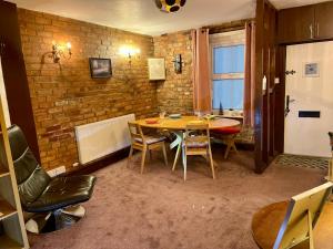 a dining room with a table and chairs and a brick wall at Cathedral View in Gloucester