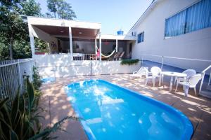 un patio trasero con piscina y una casa en Cachoeira dos pássaros, en Foz do Iguaçu