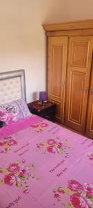 - une chambre avec un lit rose et des fleurs dans l'établissement ifrane house, à Ifrane