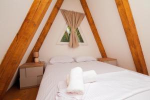 a bedroom with a white bed with two towels on it at Vukova dolina in Cetinje