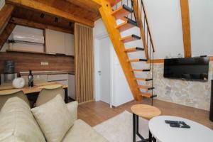 ein Wohnzimmer mit einem Sofa und einer Wendeltreppe in der Unterkunft Vukova dolina in Cetinje
