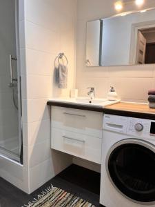 a bathroom with a sink and a washing machine at Apartament Panorama Starego Miasta in Lublin +27 photos