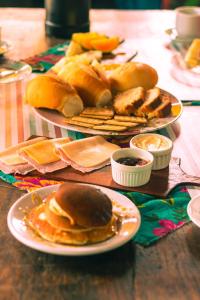 two plates of food on a table with pancakes and bread at Santo hostel in Paraty