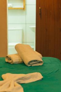 two towels sitting on top of a green table at Santo hostel in Paraty