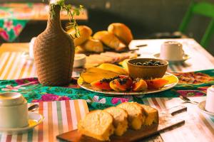 una mesa cubierta con platos de pan y fruta en Santo hostel en Paraty