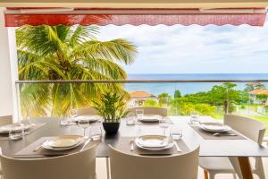 uma mesa de jantar com vista para o oceano em Appart Florida Mer 3ch Luxe em Schœlcher