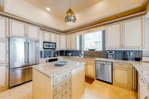 eine Küche mit weißen Schränken und Geräten aus Edelstahl in der Unterkunft Caribbean Resort 1801 - Penthouse in Navarre