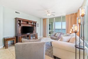 ein Wohnzimmer mit Sofa und Fernseher in der Unterkunft Beach Colony Resort West 10F in Navarre
