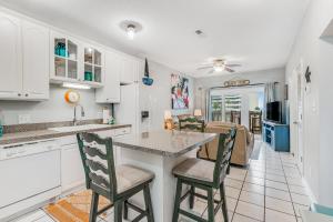 a kitchen and living room with a counter and chairs at Baywatch F2 in Pensacola Beach